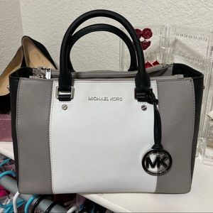 Gray, white, and black leather Micheal Kors handbag.